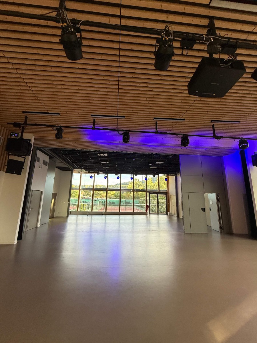 Installation d'éclairages LED dans la salle des fêtes de Rochetaillée-sur-Saône Salle des fêtes de Rochetaillée-sur-Saône avec projecteurs LED wash accrochés devant la grande baie vitrée