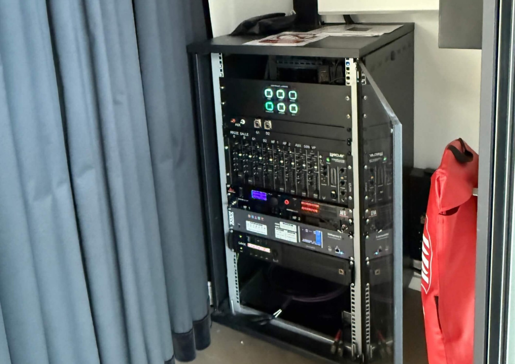 Local technique et pilotage lumière par scènes préprogrammées dans la salle des fêtes de Rochetaillée-Sur-Saône Baie technique d'une salle des fêtes avec commande lumière à 6 boutons rétroéclairés et console de mixage