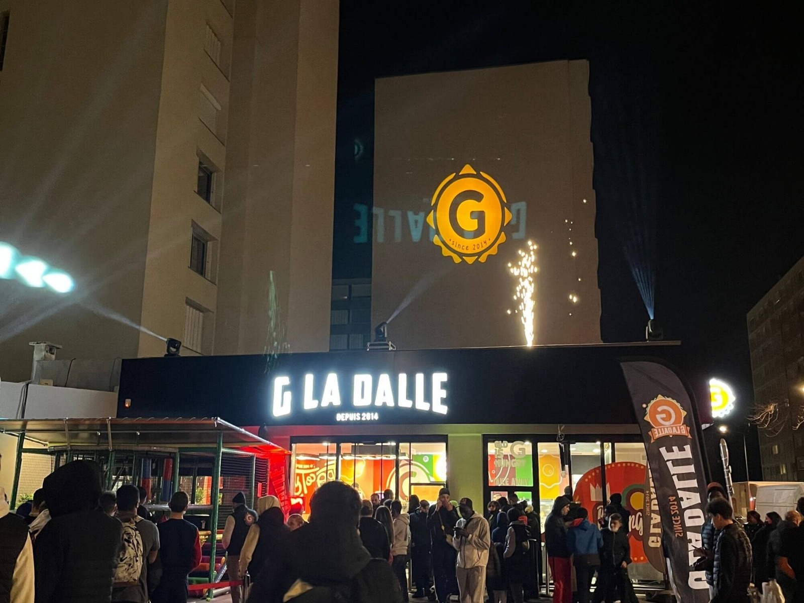 Gobo projeté sur le mur du logo G LA DALLE Lyon avec lyres et machines à étincelles