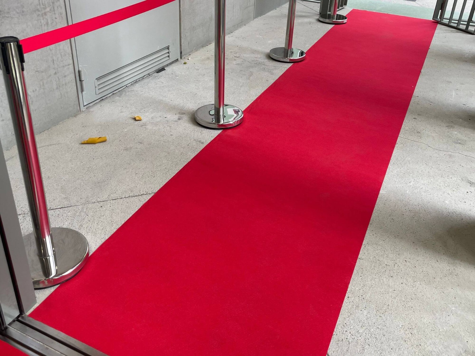 Installation de moquette rouge et poteau de guidage à l'entrée du lieu